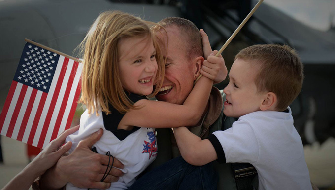 A family welcoming home their dad after a deployment